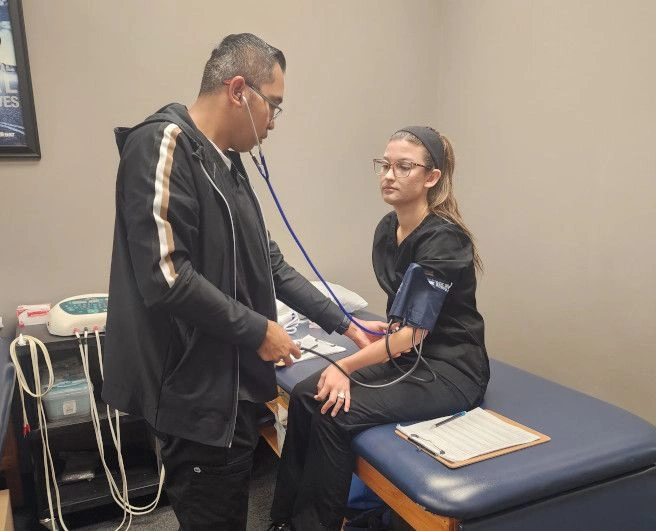 student taking another student's blood pressure student taking another student's blood pressure
